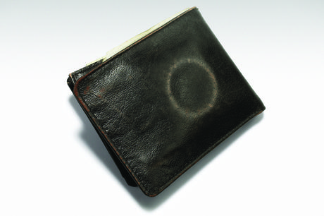 A worn leather wallet with a circular mark